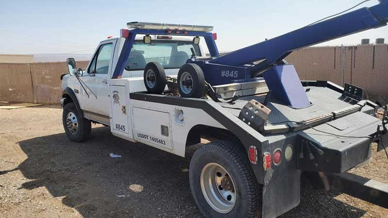 A white and blue tow truck